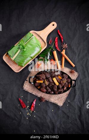 Rôti de boeuf ou pothu ulartheyadu, plat spécial kerala disposé dans une table noire et en feuille de banane de manière traditionnelle placée sur une couleur noire Banque D'Images