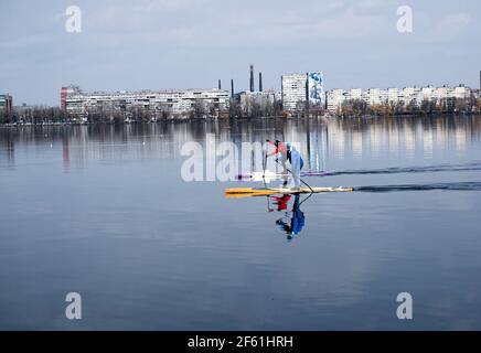 Dnepropetrovsk, Ukraine, rivière Dniepr - 28 mars 2021 : de jeunes athlètes non identifiés nagent en canoë. L'art de piloter un bateau avec un seul oar. Ressort Banque D'Images
