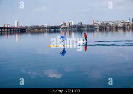 Dnepropetrovsk, Ukraine, rivière Dniepr - 28 mars 2021 : de jeunes athlètes non identifiés nagent en canoë. L'art de piloter un bateau avec un seul oar. Ressort Banque D'Images