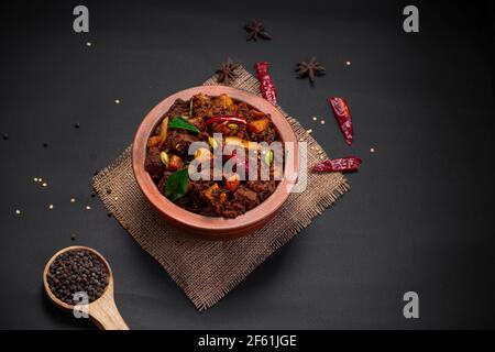 Rôti de boeuf ou pothu ulartheyadu, plat spécial kerala disposé dans une faïence de manière traditionnelle garni de pièces de noix de coco. Banque D'Images