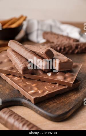 Différentes barres de chocolat sur table en bois, gros plan Banque D'Images