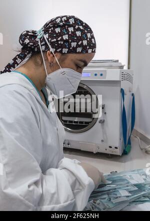 L'infirmière emballe un instrument dentaire avant sa stérilisation dans un clinique dentaire - concept de technologie moderne en médecine Banque D'Images