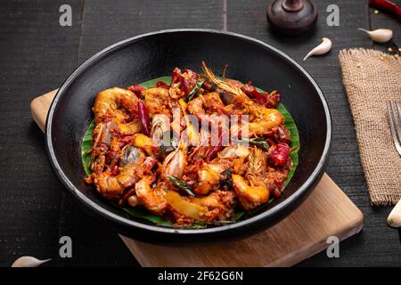 Rôti de crevettes de style Kerala ou chemmeen varattiyathu fait de rouge les flocons de piment de kashmiri et les tranches de noix de coco comme principaux ingrédients et garniture de marche Banque D'Images