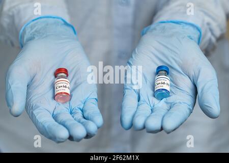 Le médecin tient deux flacons différents de vaccin contre le coronavirus covid dans les mains. Banque D'Images