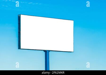 Maquette d'un grand panneau d'affichage vierge sur fond bleu ciel. Banque D'Images