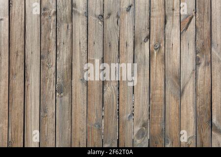 La texture d'une clôture en bois faite de bois non peint, abîmé, cloué avec des clous rouillés. Une haute résolution. Banque D'Images