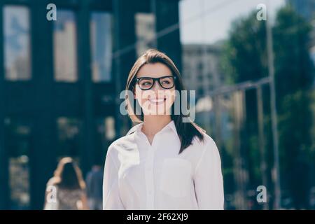 Photo de jeune belle femme d'affaires souriante et gaie dans des verres regardez l'espace publicitaire en dehors de l'extérieur Banque D'Images