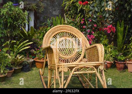 Chaise à bascule, meubles de canne dans le jardin Banque D'Images