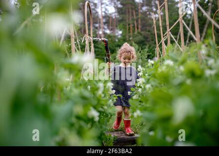 Portrait d'une petite fille marchant dans un jardin potager, mode de vie durable. Banque D'Images