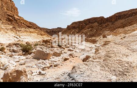 Le ruisseau Nahal Nekarot sort de la rive sud du Cratère de Makhtesh Ramon en Israël à travers le Nekarot Gap avec un ciel bleu pâle en arrière-plan Banque D'Images