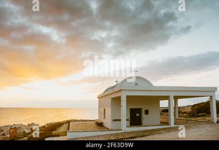 L'église Agioi Anargyeri au Cap Greco lever du soleil sur la côte méditerranéenne de la mer Chypre Banque D'Images