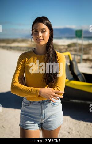 Portrait de la bonne femme de race blanche séjournant à côté de la promenade à la plage en bord de mer regardant la caméra Banque D'Images