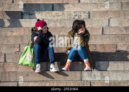 Jeune homme et jeune femme assis sur les marches de la cathédrale d'Helsinki dans l'après-midi ensoleillé du printemps à Helsinki, en Finlande Banque D'Images