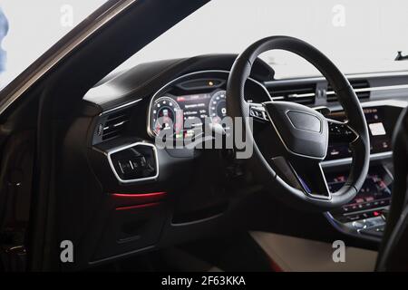 Intérieur d'une nouvelle voiture de luxe ultra moderne. Sièges en cuir et garniture en bois, panneaux tactiles avec rétroaction de vibration et commande de la température. Multifonction, transmission automatique Banque D'Images