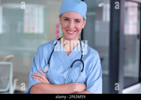 Portrait d'une femme caucasienne souriante portant des gommages et un stéthoscope Banque D'Images