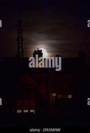 Brighton UK 29 mars 2021 - la Lune de Worm s'élève au-dessus de maisons dans le quartier Queens Park de Brighton ce soir. Ce sera la première superlune de l'année, ce qui signifie que la lune est légèrement plus proche de la Terre et semble donc plus grande et plus lumineuse dans le ciel. : crédit Simon Dack / Alamy Live News Banque D'Images