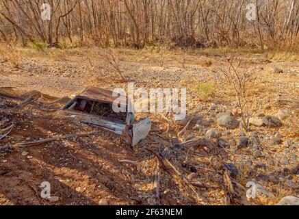 Voiture abandonnée de la fin des années 1960 partiellement enterrée le long de la rive de la rivière Verde dans le parc national de Dead Horse Ranch à Cottonwood Arizona. Banque D'Images