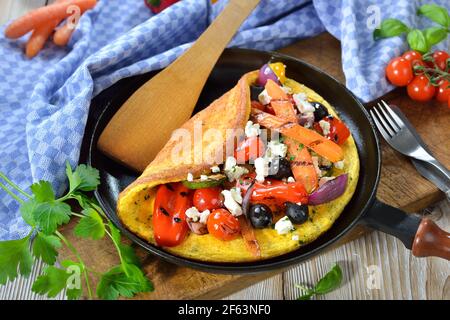 Omelette de style grec avec légumes grillés et fromage feta servis dans une poêle Banque D'Images