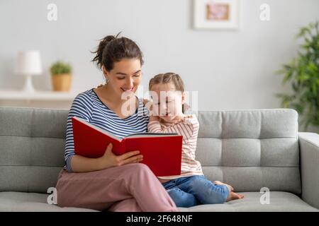 famille heureuse et aimante. jolie jeune mère lisant un livre à sa fille Banque D'Images