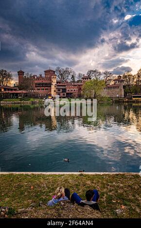 Italie Piémont Turin - Parc Valentino - 2 personnes assises Sur les rives du po en face de le village médiéval Banque D'Images