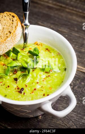 Soupe de pois verts chauds sur fond rustique. Mise au point sélective. Faible profondeur de champ. Banque D'Images