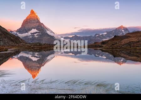 Ciel rose au lever du soleil au-dessus de Matterhorn miroir dans le lac Riffelsee, Gornergrat, Zermatt, canton du Valais, Suisse Banque D'Images