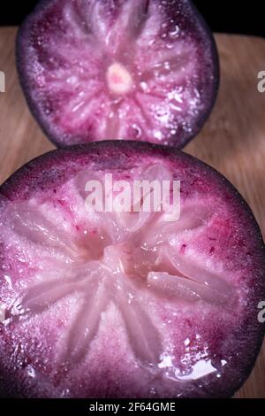 Une pomme bien mûre montrant les fruits colorés coupés en deux, un fruit populaire de saison aux Philippines. Banque D'Images