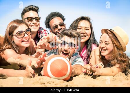 Groupe d'amis heureux multiraciaux ayant du plaisir à des jeux de plage - concept international de joie d'été et d'amitié multi-ethnique ensemble Banque D'Images