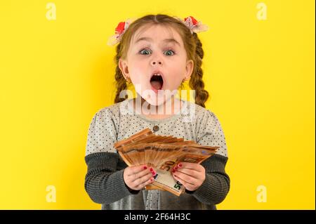 La jeune fille détient des billets en euros en coupures de 50 euros, un enfant et des billets, monnaie européenne. Nouveau Banque D'Images