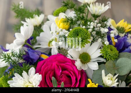 Bouquet de gros plan avec rose rouge, iris pourpre et chrysanthèmes blancs, jaunes et verts. Fond floral. Mise au point douce Banque D'Images