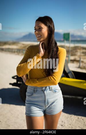 Portrait de la bonne femme de race blanche séjournant à côté de la promenade à la plage au bord de la mer, souriant Banque D'Images