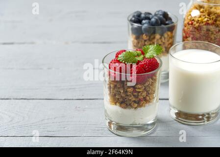 Yaourt avec granola et bleuets et framboises frais, en verre. Petit-déjeuner sain : yaourt à la sauce à la granola et aux baies Banque D'Images