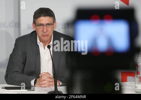 Düsseldorf, Allemagne. 30 mars 2021. Knut Giesler, Directeur de district d'IG Metall Rhénanie-du-Nord-Westphalie, suit une conférence de presse. Une caméra au premier plan enregistre l'événement. Après dix heures de négociations, le syndicat et les employeurs de l'industrie du métal et de l'électricité en Rhénanie-du-Nord-Westphalie ont conclu une convention collective. Crédit : David Young/dpa/Alay Live News Banque D'Images