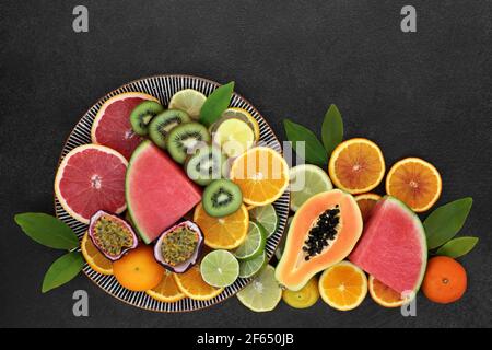 Fruits du soleil d'hiver riches en antioxydants et anthocyanines pour stimuler l'immunité avec papaye, melon, kiwi, fruit de la passion, oranges, citrons, limes, pamplemousse Banque D'Images