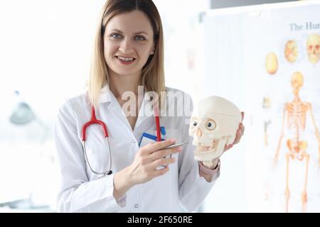 Portrait souriant medic maintient le crâne humain de près Banque D'Images
