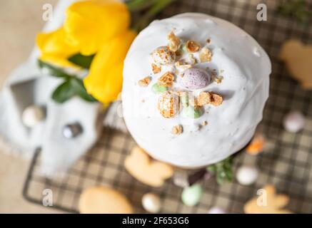 Kulich. Pain de Pâques traditionnel orthodoxe sucré décoré de glaçage meringue et d'œufs en forme de sucre sur une grille en métal noir. Mise au point sélective. Vue de dessus. Banque D'Images