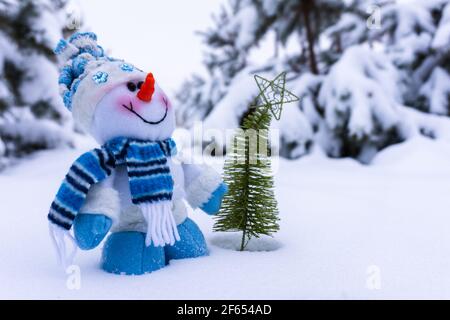 bonhomme de neige jouet dans la forêt d'hiver. Carte de Noël avec espace copie Banque D'Images