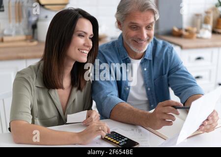 Happy couple calculant les factures à la maison, reçu la notification de prêt hypothécaire de dette, la vérification des documents financiers Banque D'Images