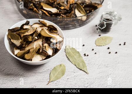 Gros plan de champignons porcini séchés sur une assiette, sous forme de séchage sur une table grise. Banque D'Images