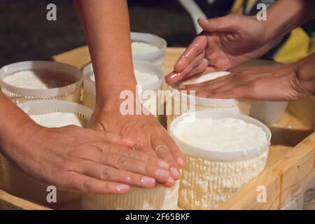 mains, fabrication à la main de fromage frais dans le processus traditionnel à apulia le pays des maisons de trulli dans le sud de l'italie; l'artisanat et la nourriture Banque D'Images