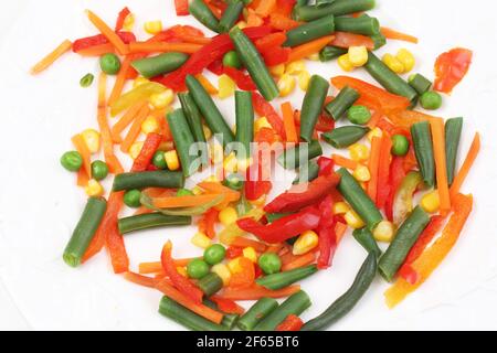 Mélange végétal de haricots verts, de maïs, de poivrons et de carottes sur fond blanc Banque D'Images