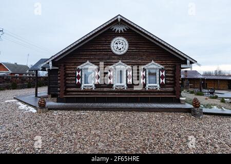 Maison en bois avec volets décoratifs sculptés sur les fenêtres. La façade d'une maison de vacances de campagne pour les touristes dans un style européen traditionnel Banque D'Images