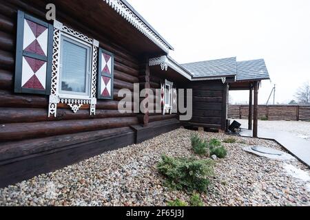 Maison en bois avec volets décoratifs sculptés sur les fenêtres. La façade d'une maison de vacances de campagne pour les touristes dans un style européen traditionnel Banque D'Images