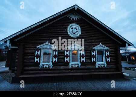 Maison en bois avec volets décoratifs sculptés sur les fenêtres. La façade d'une maison de vacances de campagne pour les touristes dans un style européen traditionnel Banque D'Images