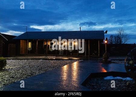magnifique cabane en bois. l'éclairage nocturne des lanternes illumine la cour d'une maison privée Banque D'Images