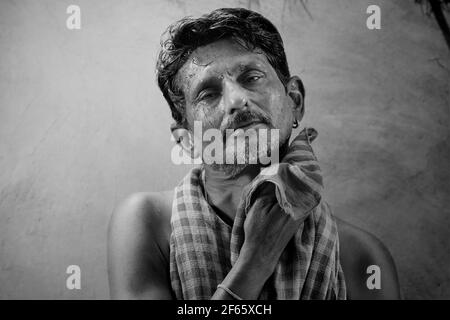 Un fermier essuyant sa sueur avec un chiffon rouge Banque D'Images