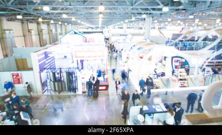 Arrière-plan flou : les gens dans expo Fair avec la lumière de bokeh. Photo de haute qualité Banque D'Images