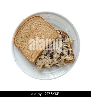 Vue de dessus d'un sandwich maison de salade de poulet avec des canneberges et du céleri sur du pain de blé isolé sur un fond blanc. Banque D'Images