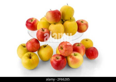 pommes fuji et pommes dorées sur une plaque surélevée en verre transparent, fruits rouges et jaunes isolés sur fond blanc Banque D'Images