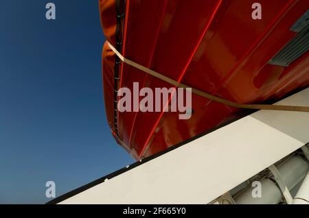 Le dessous rouge vif d'un canot de sauvetage sur le MS Cendrillon, un bateau de croisière de la mer Baltique. Banque D'Images